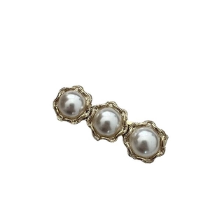 Elegant gold-tone hair clip with three pearls and rhinestone accents on a white background