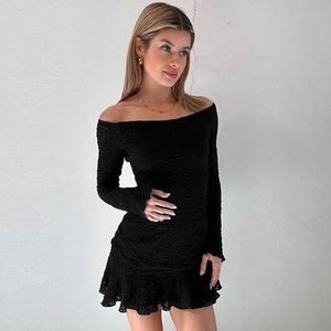 Close-up of the 3D textured ruffled fabric on a slim fit black off-shoulder dress