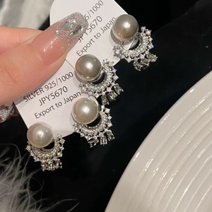 Detail of 925 silver pearl earring with sparkling rhinestones and elegant grey pearl