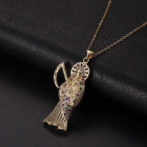 Détail du pendentif de la faucheuse en cuivre serti de zircons avec auréole et faux dorée