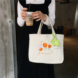 Quilted white tote bag with rabbit embroidery and green flower charm for daily use