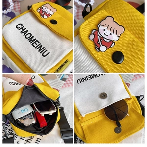 Detail view of mini canvas crossbody bag showing inner capacity and cute badge decoration