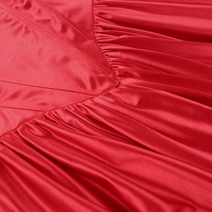 Detailed macro view of pleated red satin fabric with elegant sheen and smooth texture