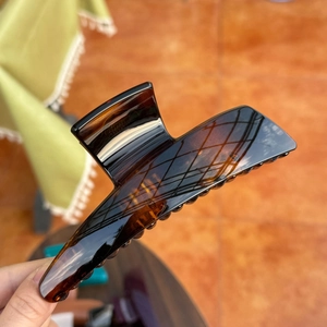 Close-up of a large amber tortoiseshell hair claw clip showing resin texture and shine