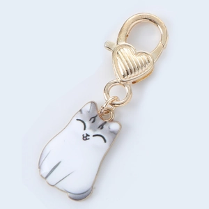 Detail view of a white enamel cat pendant with a gold heart and lobster clasp