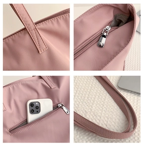 Detail view of pink nylon tote showing reinforced stitching, metal zipper and anti-theft pocket
