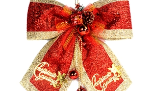 Detail of red and gold Christmas bow featuring pine cone, bells, and glitter textures