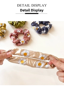 Detail display showing elastic daisy print satin scrunchies in various vibrant colors