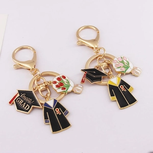 Gold graduation keychains with black doctoral caps and colorful flower charms