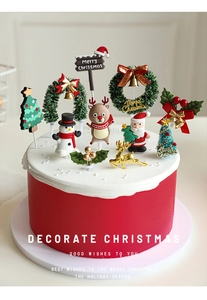 Close-up of festive Santa and reindeer cake toppers on a Christmas themed cake