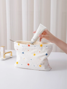 Minimalist white canvas makeup bag with colorful embroidery and a convenient zipper closure