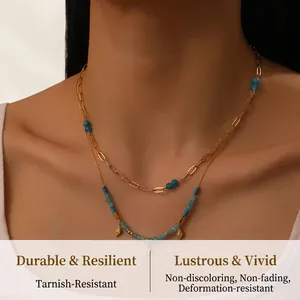 Detail of layered gold O-chain necklace with blue beads and rhombus pendant on model neck