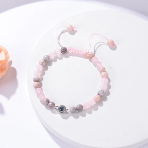 Detail of pink zebra stone projection bracelet with adjustable braided rope and beads