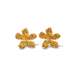 Détail macro de boucles d'oreilles fleur dorées avec texture martelée et finition organique