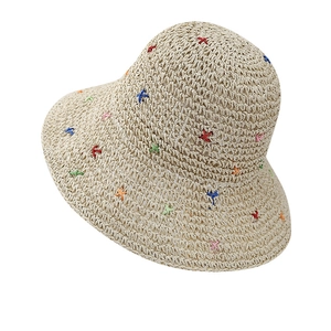 Handcrafted straw sun hat with colorful X-embroidery and wide brim for summer beach trips