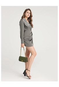 Side view of a grey satin wrap dress with a green quilted chain strap shoulder bag