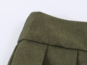 Gros plan sur la jupe plissée vert armée avec les détails du tissage en coton et lin