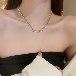 Close-up of a silver leaf sequin tassel choker necklace on a female model neck