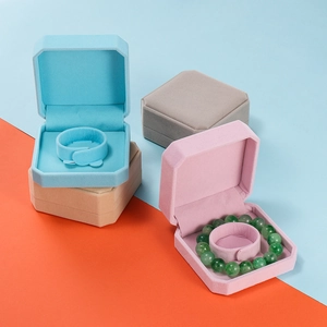 Detail view of octagonal velvet bracelet boxes in cyan pink grey and khaki colors