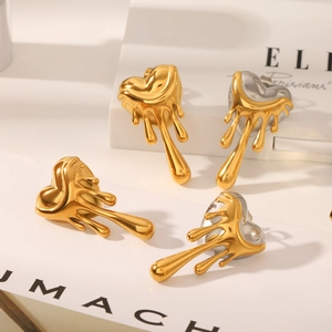 Detail shot of heart-shaped lava stud earrings in gold and silver on a book