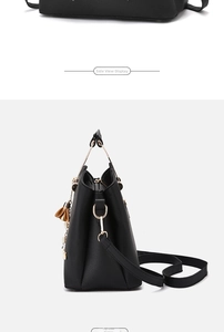 Detail of black lychee grain leather handbag with gold D-ring and metal handles