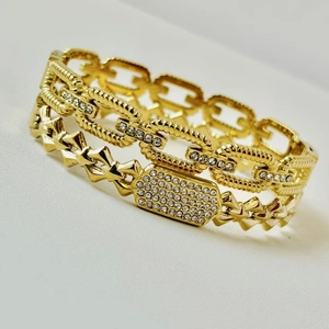 Macro detail of gold link bracelet featuring hollow chain design and sparkling rhinestones