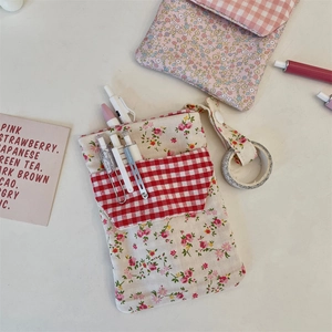 Detailed view of floral nurse pocket pouch organizer with red checkered pocket for pens