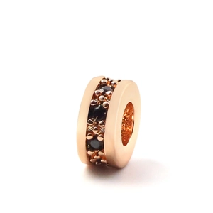 Macro detail of rose gold bead charm with black cubic zirconia micro-pave setting