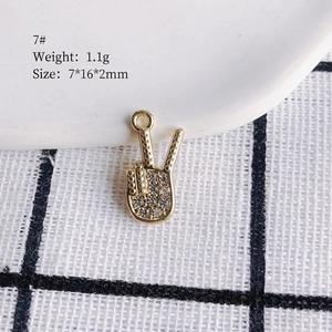 Macro shot of 7x16mm gold victory hand charm with white rhinestones for DIY jewelry