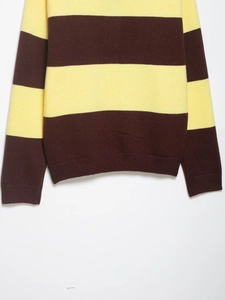Detail eines gelb und dunkelbraun gestreiften Strickpullovers mit geripptem Saum und Bündchen
