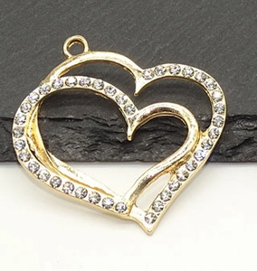 Macro shot of gold-plated hollow heart pendant with sparkling crystals for jewelry DIY