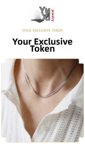 Close-up of a three-layer silver-tone titanium steel necklace on a model wearing white knitwear