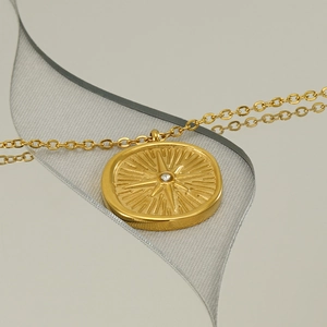 Golden stainless steel sunburst star pendant necklace with central sparkling crystal