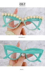 Dettaglio degli occhiali da sole cat-eye verde menta con fiori di perle dorate e strass