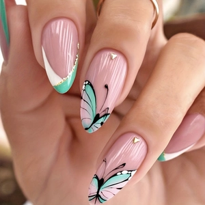 Détail de faux ongles French vert menthe et blancs avec motif papillon et accents dorés