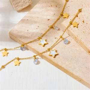 Gold stainless steel star and gemstone necklace set on elegant travertine tiles