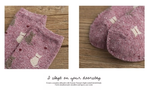Detail of marled red knit socks featuring cute cat and heart patterns with ribbed cuffs