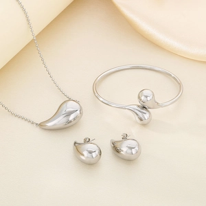 Polished silver jewelry set featuring teardrop necklace, open bangle, and stud earrings
