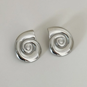 Macro shot of silver spiral nautilus seashell stud earrings with a polished finish