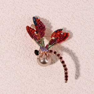 Elegant gold dragonfly brooch with colorful rhinestones and a large pearl center