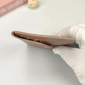 Slim pink leather card holder with multiple card slots and detailed edge stitching