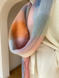 Close-up of thick gradient plaid scarf with soft plush texture and long fringe details