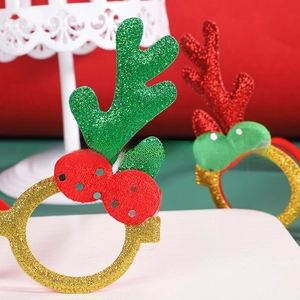 Close-up of Christmas glitter reindeer antler glasses with red berries for party props