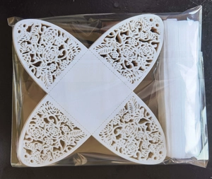 Flat lay of white laser-cut rose hollow favor box with butterfly shape and silk ribbon