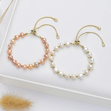 Detail of white and pink pearl bracelets with adjustable gold clasps and metal beads