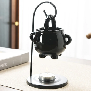 Ceramic witch cauldron oil burner with black metal stand and tealight candle holder