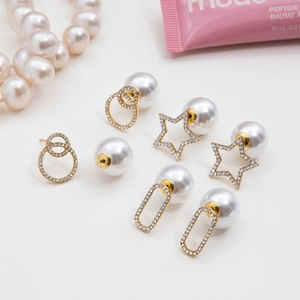 Detailed view of gold plated rhinestone earrings with large white ABS pearl jackets
