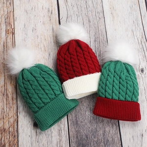 Detailed knit patterns and white pom-poms on green and red Christmas beanies