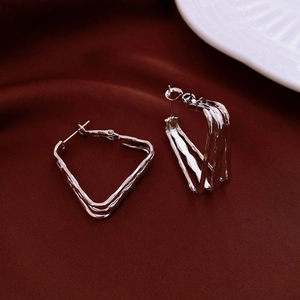 Macro detail of geometric silver multi-strand earrings on vintage velvet background
