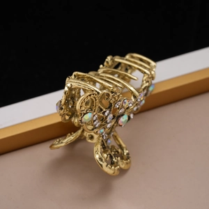 Detail of vintage gold metal hair claw clip with colorful rhinestones and floral design